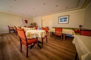 a dining room with tables and chairs in a restaurant at Gästehaus Hubertus Garni in Bad Peterstal-Griesbach