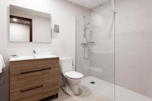 a bathroom with a toilet and a glass shower at Hostal Vila del Mar in Lloret de Mar