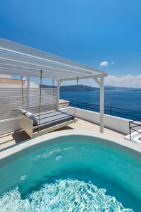 uma piscina numa casa com o oceano ao fundo em Kaleidoscope Oia Suites em Oia