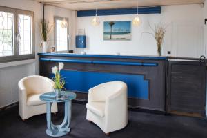 a living room with a fireplace and two chairs and a table at Hôtel Bel Azur in Six-Fours-les-Plages