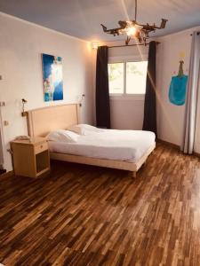 Un dormitorio con una cama grande y una ventana en Hotel Ariana, en Marine du Miomo