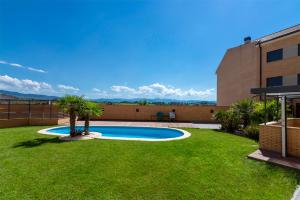 una piscina in un cortile con palme di Apartamentos Turísticos Rioja y Camino a Huércanos