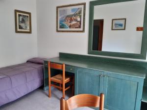 Habitación con sofá y espejo sobre un escritorio. en Villaggio Alkantara en Giardini Naxos