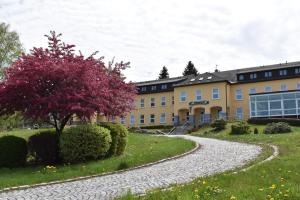 ein Gebäude mit einem Schotterweg vor einem Gebäude in der Unterkunft Kurhotel Bad Schlema in Bad Schlema