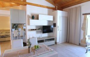 ein Wohnzimmer mit weißen Schränken und einem TV in der Unterkunft Casa al Teatro in Syrakus