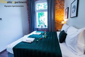 a room with a bed with a green table cloth at Baltic Apartments - Apartamenty Loft in Świnoujście