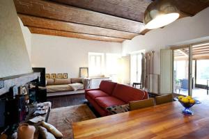 a living room with a red couch and a table at Agriturismo Antico Podere Il Polveraio in Montescudaio