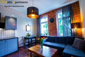 a living room with a couch and a table at Baltic Apartments - Apartamenty Loft in Świnoujście