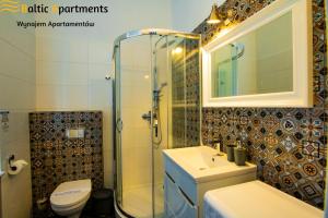 a bathroom with a shower and a sink and a toilet at Baltic Apartments - Apartamenty Loft in Świnoujście