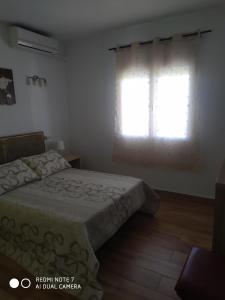 um quarto com uma cama e uma janela em BUNGALOW CHARO em Torre de Benagalbón