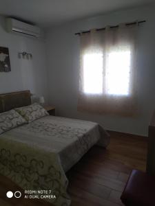 un dormitorio con una cama y una ventana en BUNGALOW CHARO, en Torre de Benagalbón