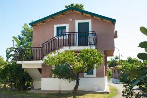 una casa con un balcón en el lateral. en Villaggio Alkantara en Giardini Naxos