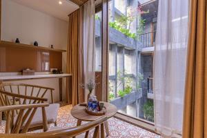 een kamer met een tafel en stoelen en een groot raam bij Le Boutique Danang in Da Nang