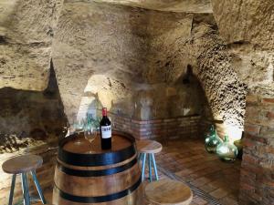 barril de vino con una botella de vino y dos taburetes en La Casa de las Tinas 2 en Sajazarra