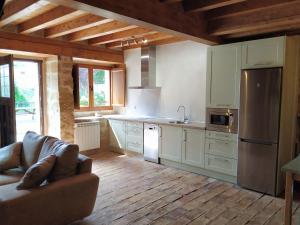 a kitchen with white cabinets and a couch in a room at La Casa de las Tinas 2 in Sajazarra