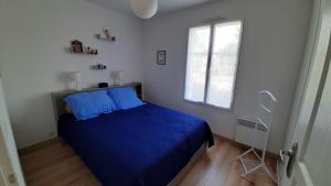 a bedroom with a blue bed and a window at PAREE D EAU 104 - Résidence avec piscine - Appartement rez de jardin 1 chambre in Notre-Dame-de-Monts +27 photos