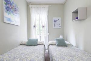 - 2 lits dans une chambre avec fenêtre dans l'établissement Camp Nou , Fira Barcelona Apartment, à L'Hospitalet de Llobregat