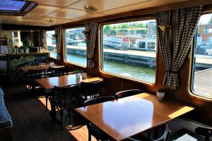 a restaurant with wooden tables and chairs and windows at Passengership Avanti in Amsterdam