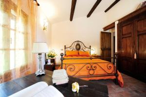 a bedroom with a bed with orange pillows on it at Cornio Delle Fronde in Fontecorniale