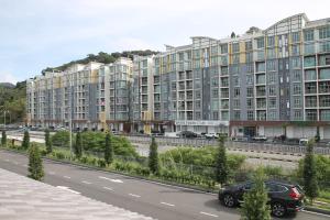 ein Auto, das vor einem großen Gebäude eine Straße hinunterfährt in der Unterkunft Bricks Terrace House 4R 3BR (Near to Night Market) in Brinchang