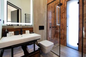Un baño con lavabo, inodoro y ducha. en Die SONNE, en Bukovel 18 fotos más