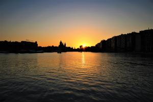 a sunset over a river with a city at Passengership Avanti in Amsterdam