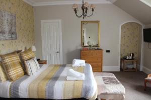 a bedroom with a bed and a dresser and a mirror at Moyness House in Inverness
