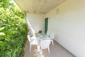 einen Tisch und Stühle auf einer Terrasse mit Pflanzen in der Unterkunft Stork Family Camping Village in Giulianova