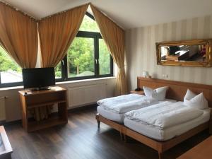 a bedroom with two beds and a mirror at Burg Wegberg Hotel & Eventlocation in Wegberg