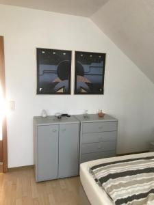 een slaapkamer met een bed, een dressoir en 2 ramen bij Ahorn 11 in Laumersheim