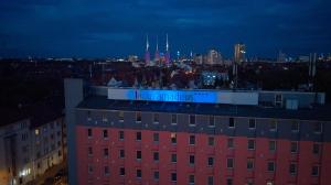 a building with a sign on the top of it at Hotel Amadeus in Hannover