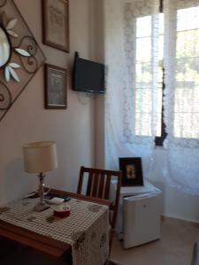 Zimmer mit einem Tisch und einem Schreibtisch mit einer Lampe in der Unterkunft Camera per breve periodi in Iglesias