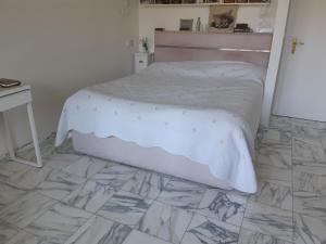 a bedroom with a bed and a tiled floor at Résidence climatisée, belle vue, 5min de la plage. in Roquebrune-Cap-Martin