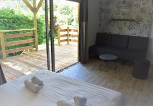 a bedroom with a bed and a view of a deck at Lodges du Sancy in Murol