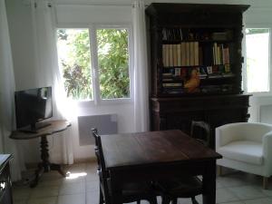 een woonkamer met een houten tafel en een televisie bij Érable Pourpre in Saint-Georges-Haute-Ville