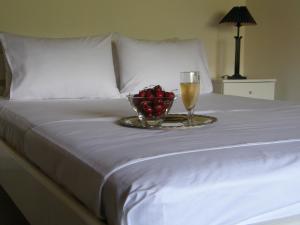 een fruitschaal en een glas wijn op een bed bij Orfeas -Vacation Home in Paralia Panteleimonos