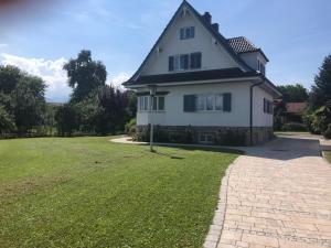 ein großes weißes Haus mit einem Rasenplatz in der Unterkunft Ferienhaus Chiemsee in Übersee