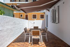 una mesa de madera y sillas en un patio con techo en Villa Siora Agiolina, en Argostoli