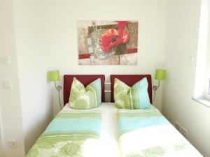 グロースレッシェンにあるFerienwohnung Seenlandのベッドルーム1室(ベッド2台付)が備わります。壁には絵画が飾られています。