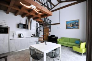 a living room with a white table and a green couch at Hotel Marzia Holiday Queen in Caorle