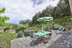 een patio met een tafel met een parasol en stoelen bij C'era una volta in Capoliveri