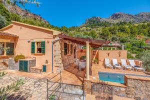 a house with a patio and a swimming pool at Ca n'aina in Cala Tuent
