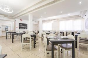 una grande sala da pranzo con tavoli e sedie di Hotel Rosalba a San Mauro a Mare