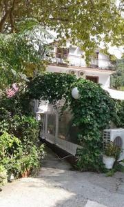 a building with an arch of ivy in front of it at Pansion Mimoza in Herceg-Novi