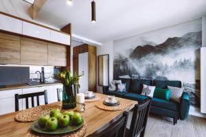 a kitchen and living room with a wooden table and a dining room at Górskie Klimaty Sarnia in Karpacz