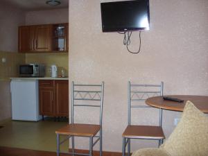 a kitchen with a table and two chairs and a tv on a wall at Pokoje typu Studio OLSZYNA in Ustronie Morskie
