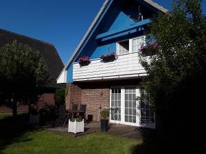 a house with white doors and flowers on the window at Haus Karlo in Büsum