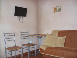 a living room with a couch and a table and a tv at Pokoje typu Studio OLSZYNA in Ustronie Morskie