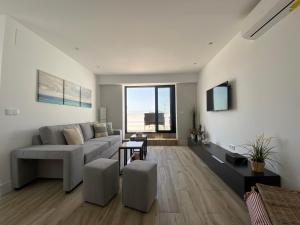 a living room with a couch and a large window at Aticos Concepción Centro in Córdoba