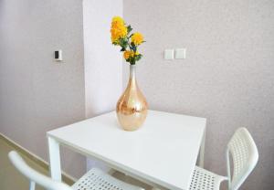 a vase with yellow flowers sitting on a table at KeyHost - Frankfurt 1307 in Dubai